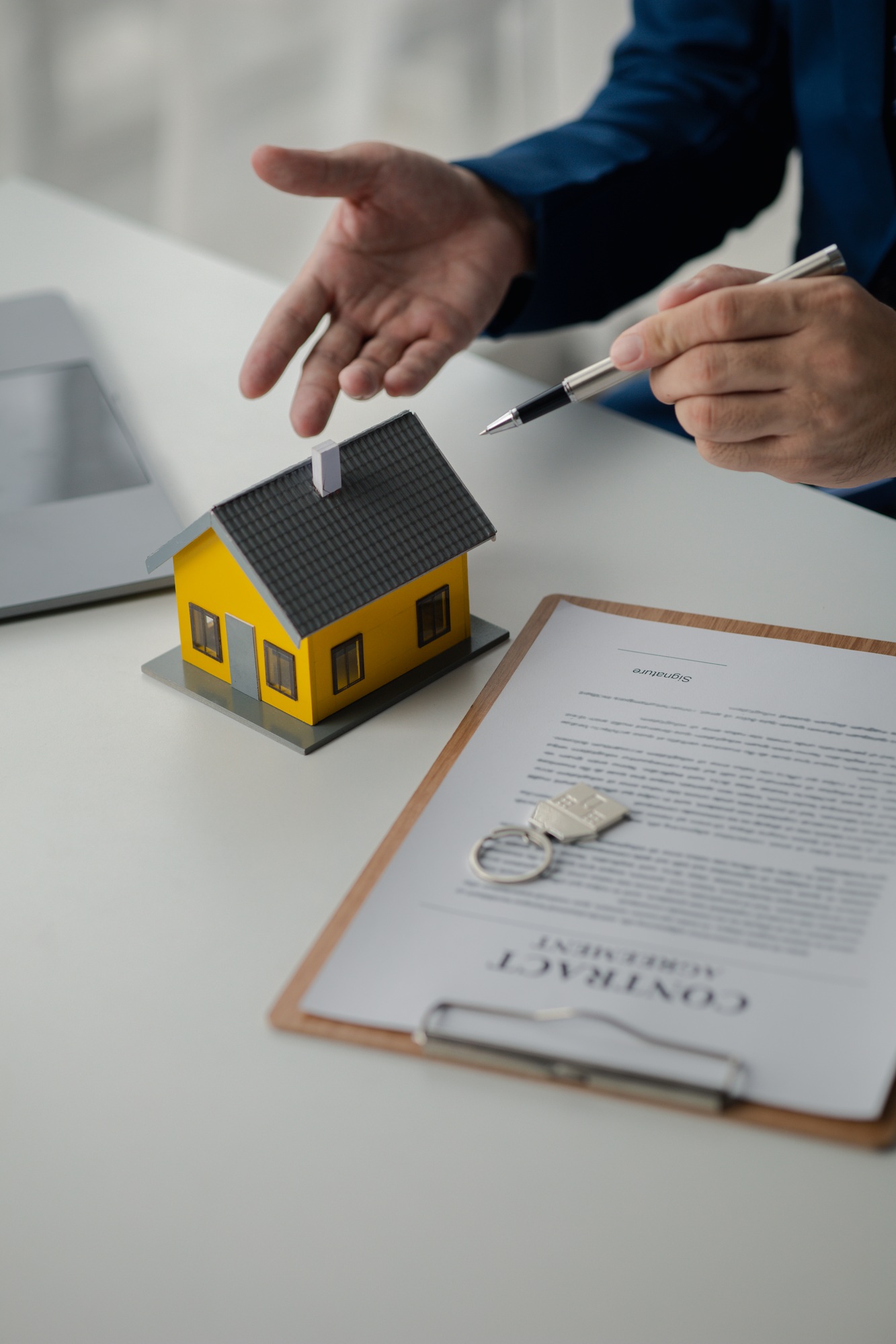 House and real estate agents, house salesmen with house models and house purchase contract documents